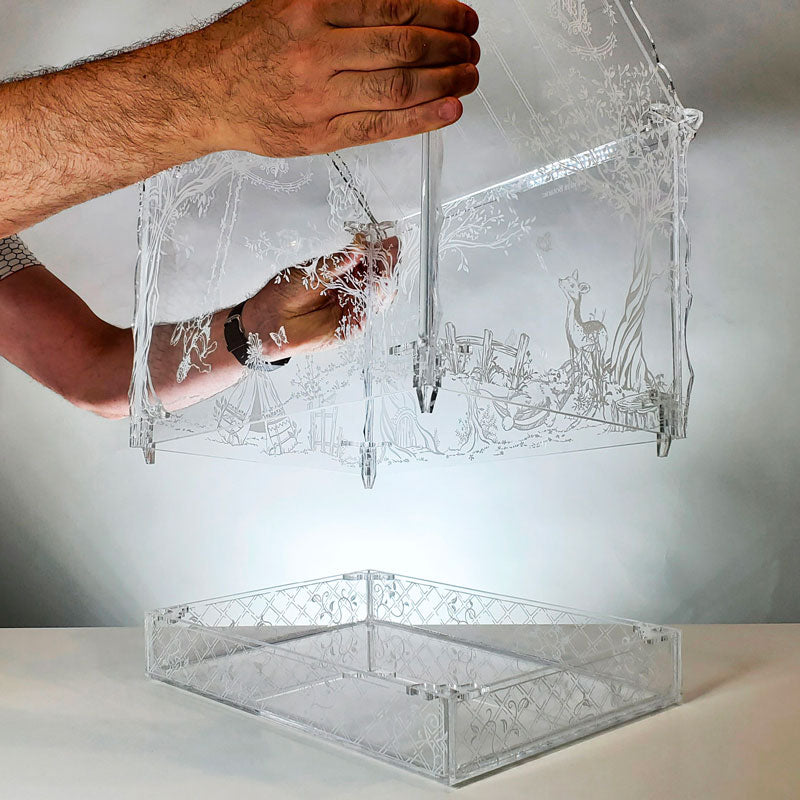 Demonstrating how to remove the top of the Victorian-style terrarium for easy plant care and maintenance.