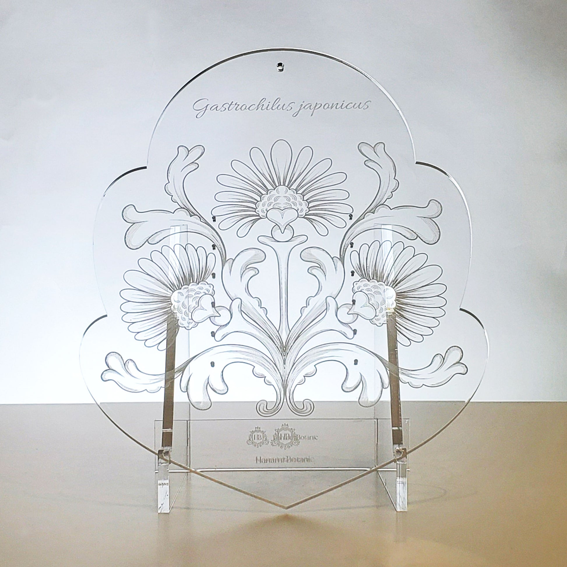 Detailed view of the intricate floral engraving on the crystal-clear acrylic epiphyte mount